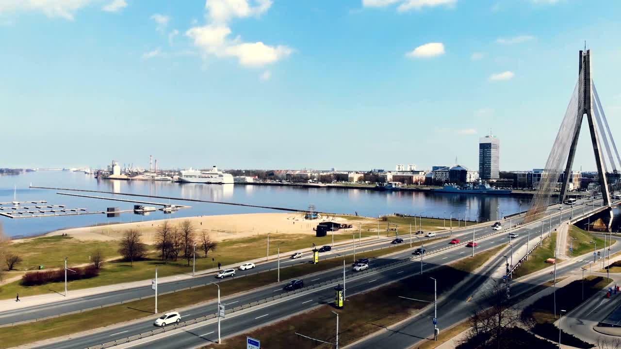 воздушный вид над мостом в центр города, рига, латвия, кадры с дронов. движущиеся машины на мосту и шоссе, городской ландшафт