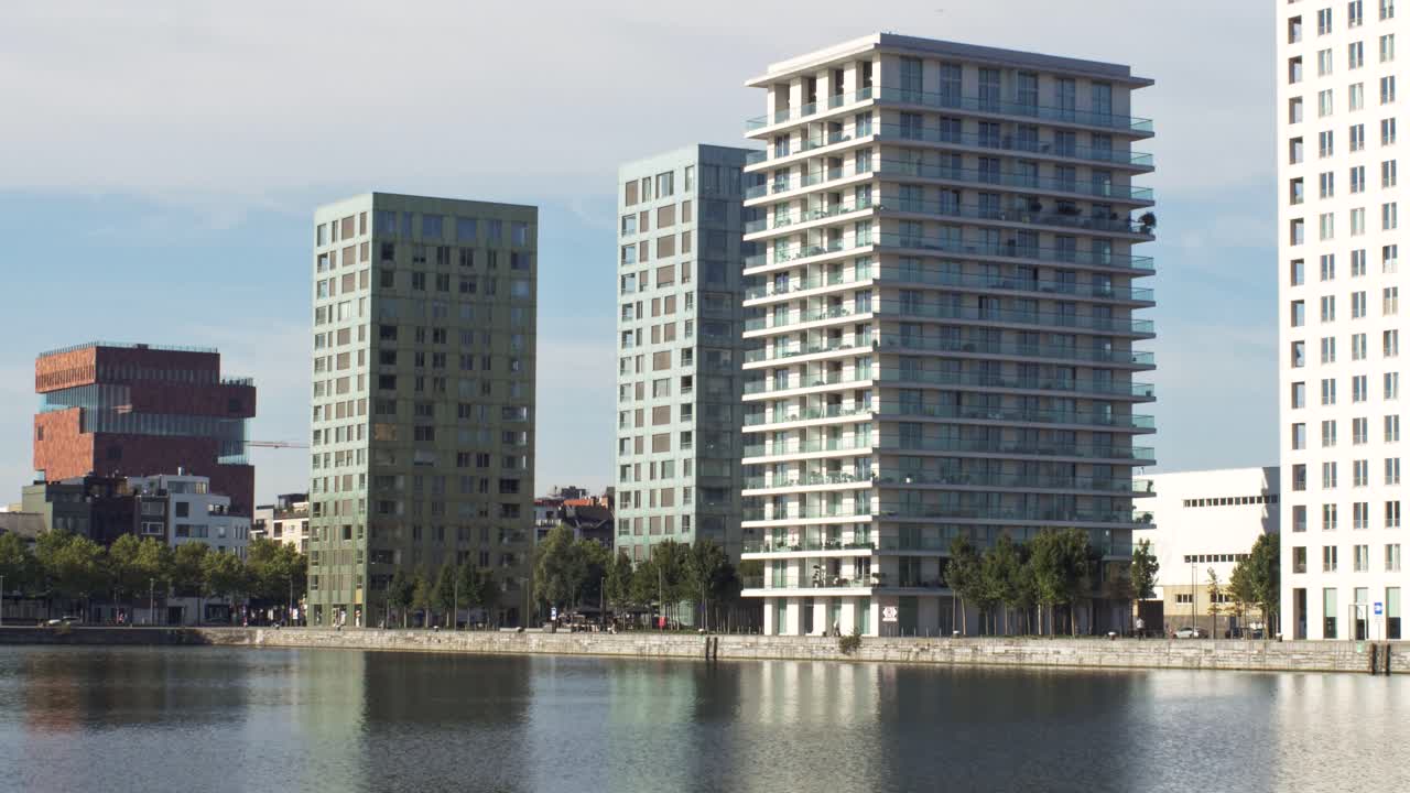Walking view of Eilandje waterfront high-rises in Antwerp with MAS museum in the background