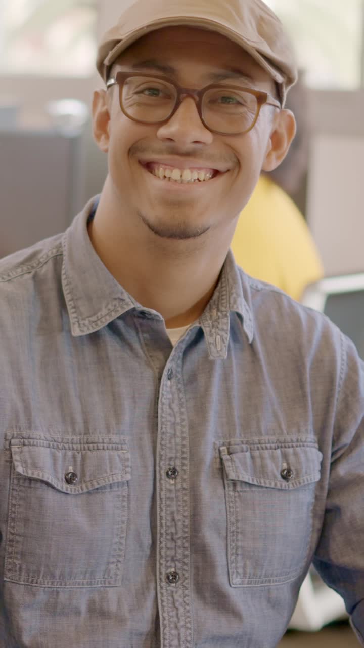 Productive man using computer and then smiling in a coworking