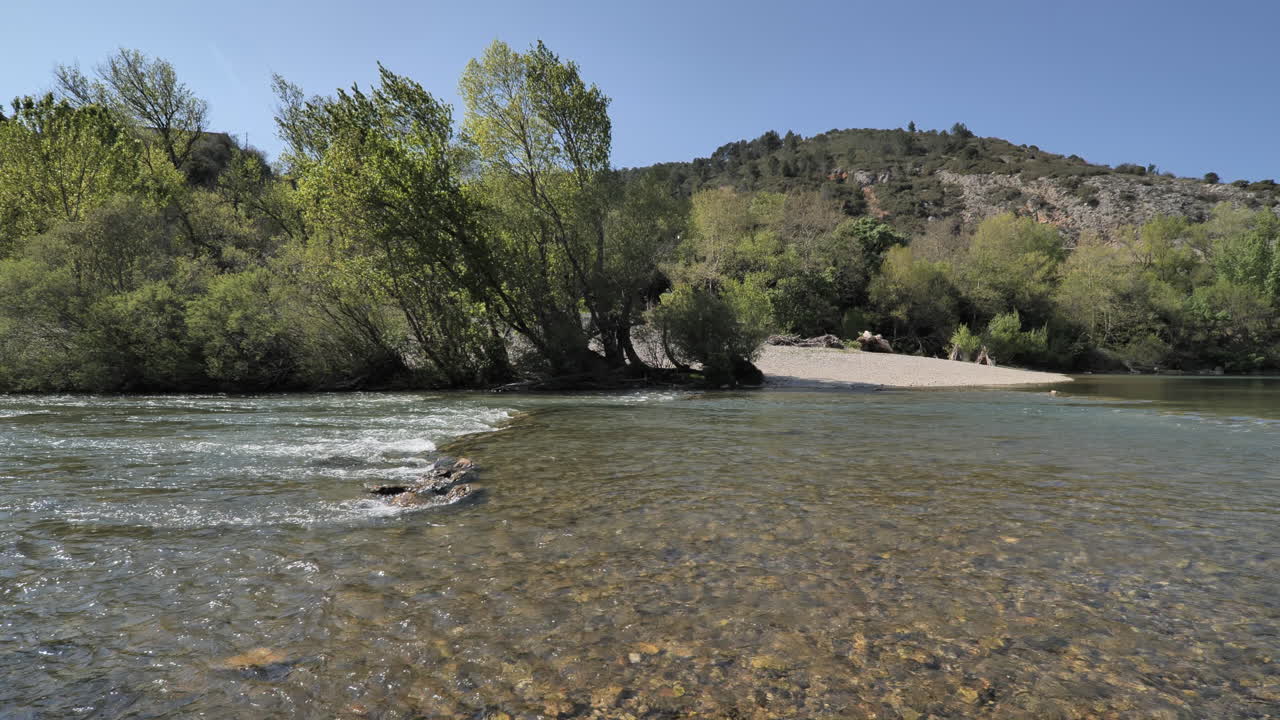 río tranquilo y viejo puente con árboles a lo largo durante la primavera en el sur de francia