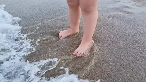 sea waves splashing baby legs on the sandy beach