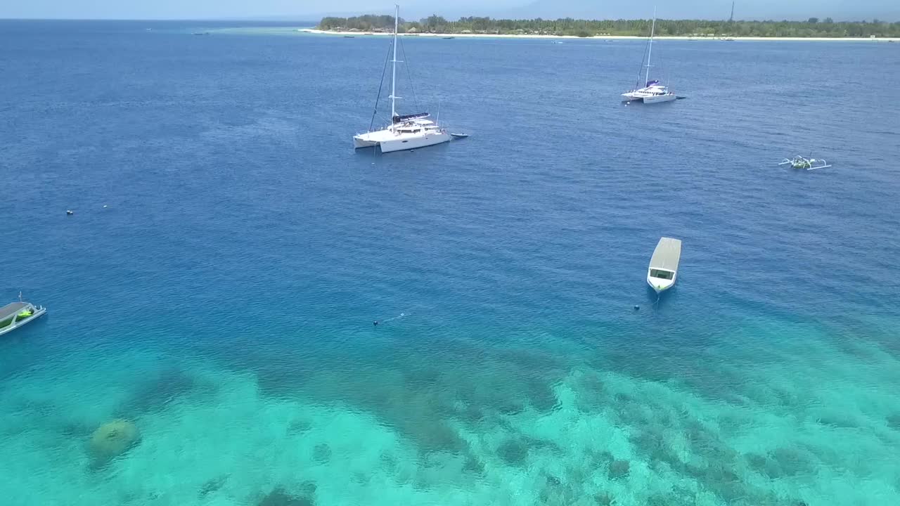 anclas de catamarán frente a la isla de los sueños vista aérea suave y mantecosa vuelo inclinado hacia abajo imágenes de drones de gili trawangan dream beach lombok en el verano de 2017 vista cinematográfica desde arriba por philipp marnitz