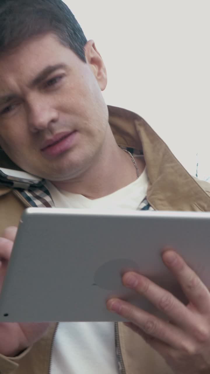Man using tablet and talking on phone