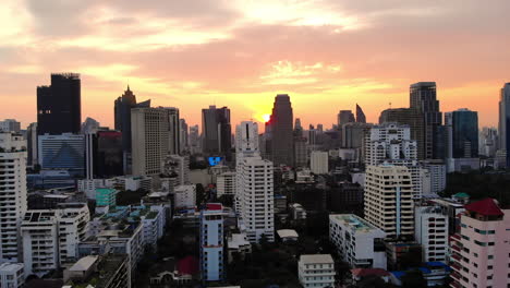 Vista-Aérea-De-Los-Rascacielos-De-Bangkok-Al-Amanecer---El-Sol-Aparece-Al-Final