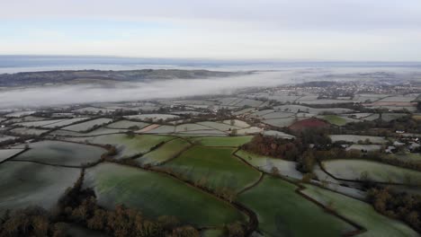 aerial panning left shot of farmland on a misty frosty morning in devon england