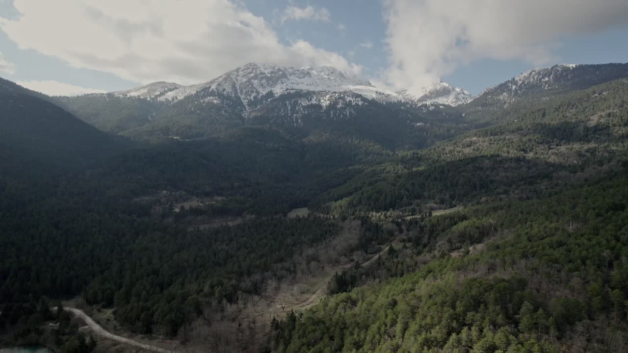 drone aéreo sobre el bosque de pinos corinthia grecia zona montañosa en el lago doxa, picos nevados y horizonte del cielo, destino europeo de viajes y turismo