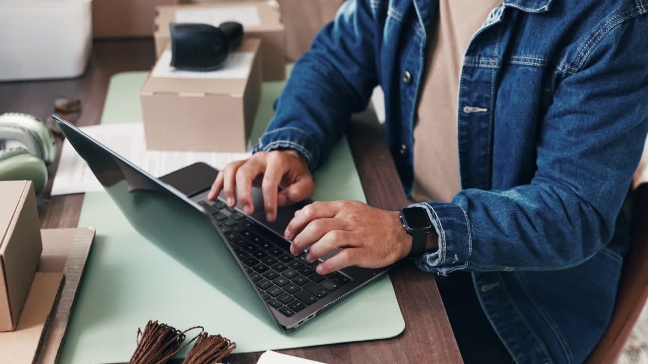 Persona che digita al laptop alla scrivania con scatole di cartone
