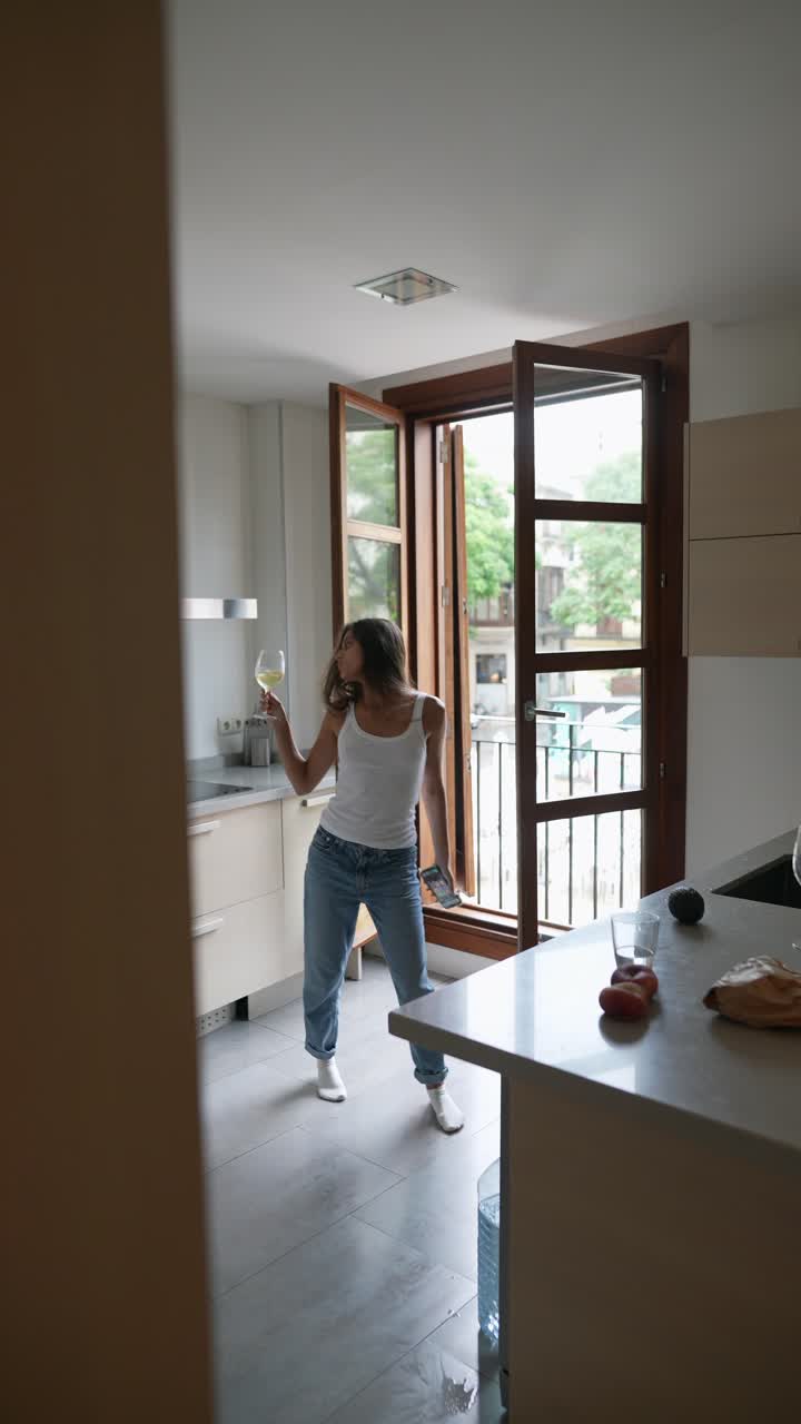 Mujer disfrutando de una copa de vino en su cocina moderna