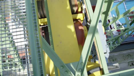 top view of the gears and steel cable of a crane unloading a ship