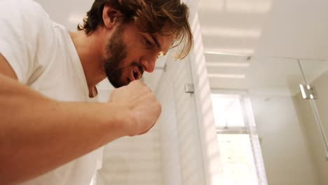 man brushing his teeth in bathroom