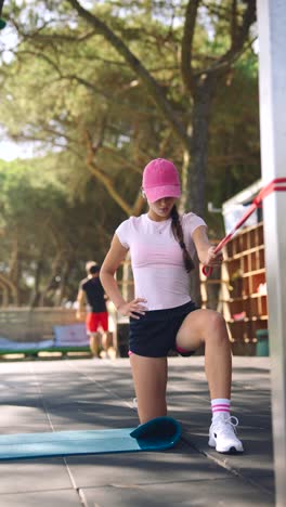 mujer haciendo ejercicio al aire libre con banda de resistencia