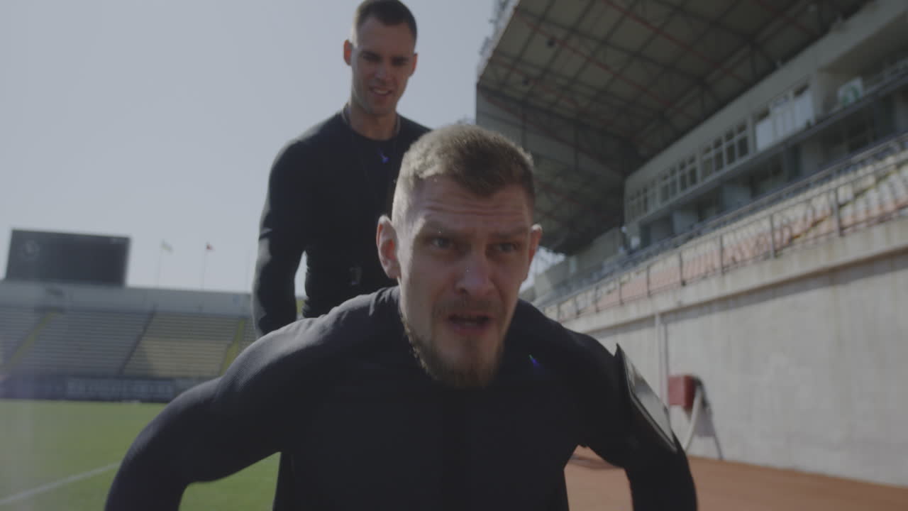 Trainer Encouraging Disabled Athlete Medium Shot of a Disabled Athlete Rolling with Wheelchair while being Encouraged by his Trainer