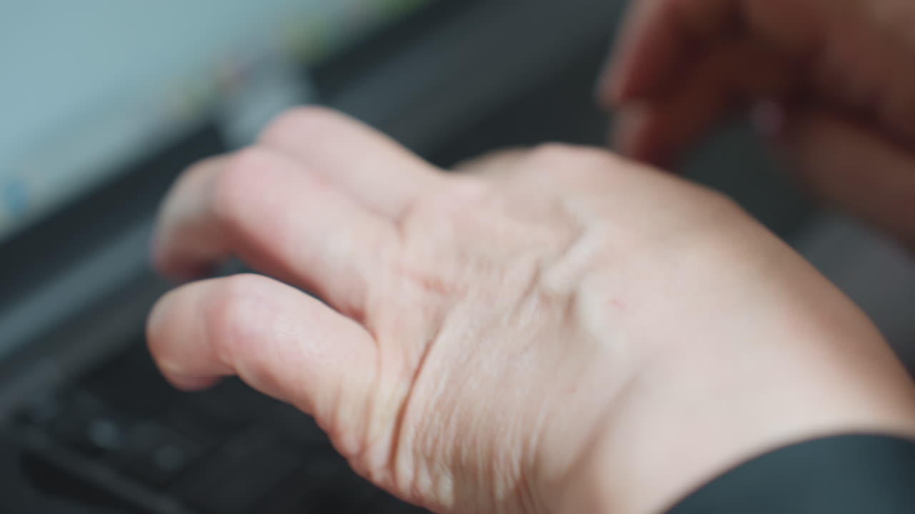Close up of woman hands typing on laptop with pink painted nails, slightly blurred background and foreground emphasize motion, touchpad visible