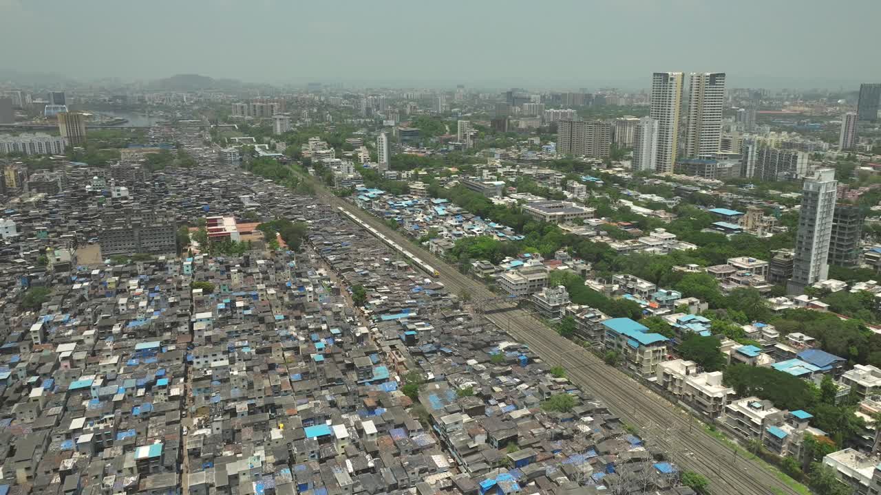 воздушный статический снимок поезда, проходящего рядом с трущобой дхарави в мумбаи, индия