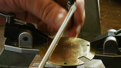 hand of horologist using screwdriver