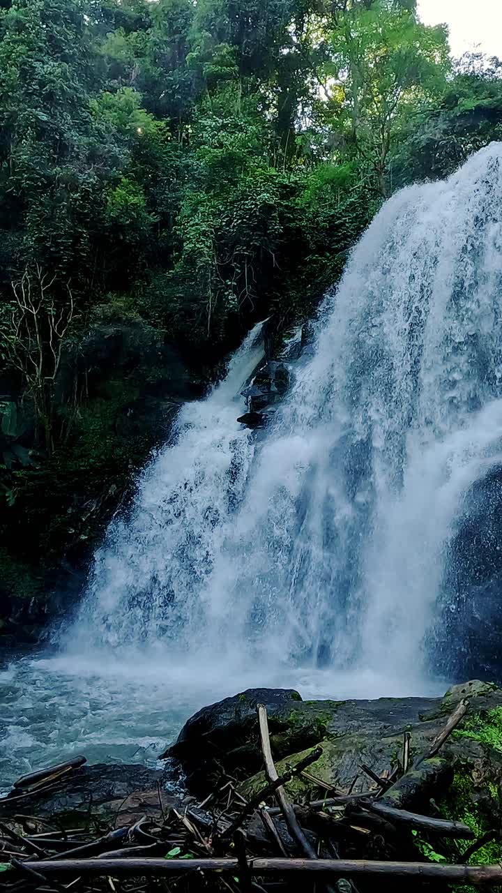 Geser ke kanan dari air terjun Wachirathan yang bertingkat ke jalan setapak dan jembatan bambu yang mengarah ke sana, Taman Nasional Doi Inthanon di Chiang Mai, Thailand