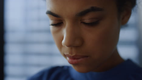 african woman face closeup.. thoughtful businesswoman using smartphone