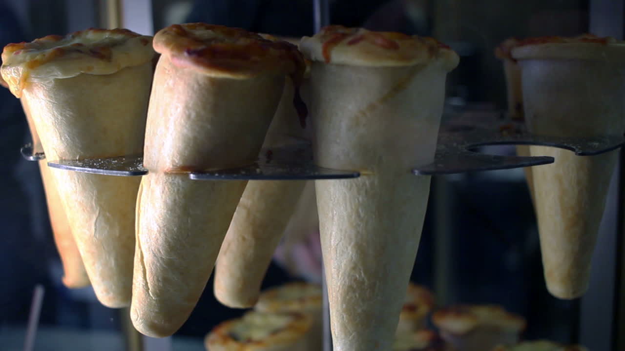 pizza de cono en un puesto giratorio. comida rápida en la calle. deliciosa pizza de cono