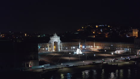 Muñeca-Aérea-En-Vista-Nocturna-De-La-Plaza-Praca-Do-Comercio-Y-El-Monumento-Arco-Da-Rua-Augusta-Con-Luces-Brillantes-En-Lisboa,-Portugal