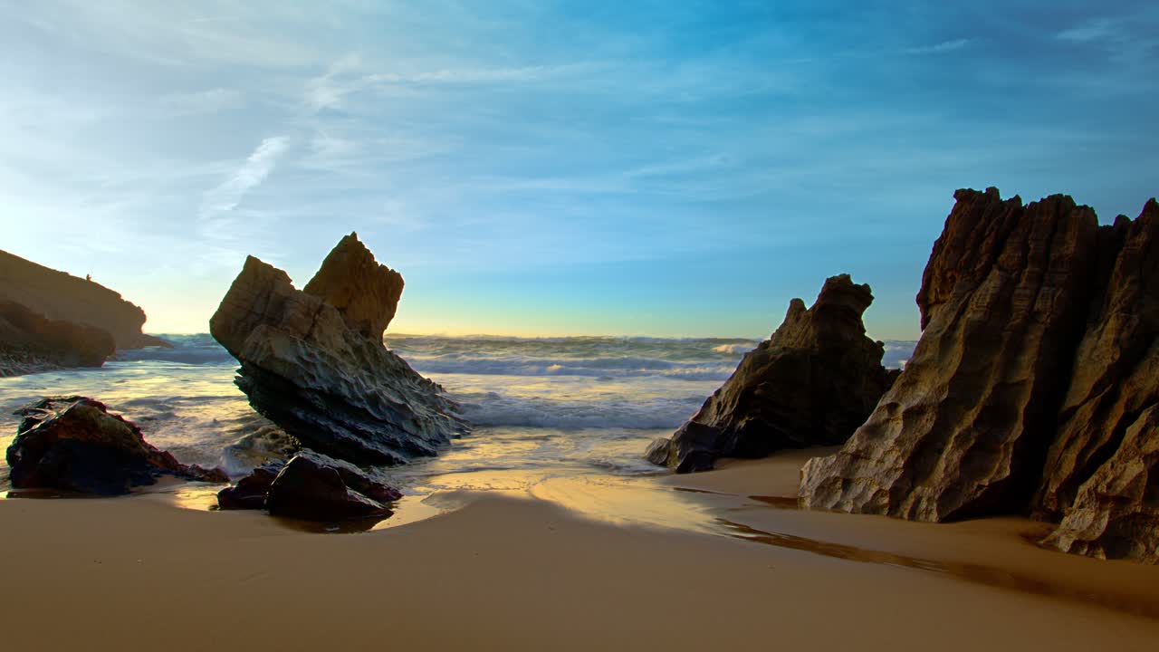 las olas del océano salpican el flujo de choque en la playa atlántica volcánica rocosa durante la épica puesta de sol panorámica.