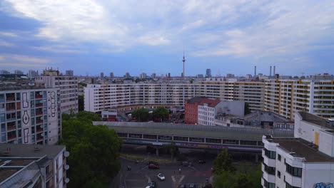 Torre-De-Televisión,-Majestuosa-Vista-Aérea-Superior-Vuelo-Ciudad-Berlín-Estación-De-Tren-Suburbano-Edificio-Prefabricado-Rascacielos-Distrito-Neukoeln,-Alemania-Día-De-Verano-2023