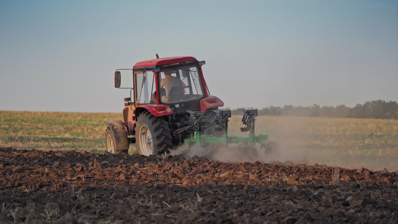 Tractor working in the field. Tractor cultivating and seeding a dry field