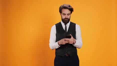 stylish waiter uses smartphone to text