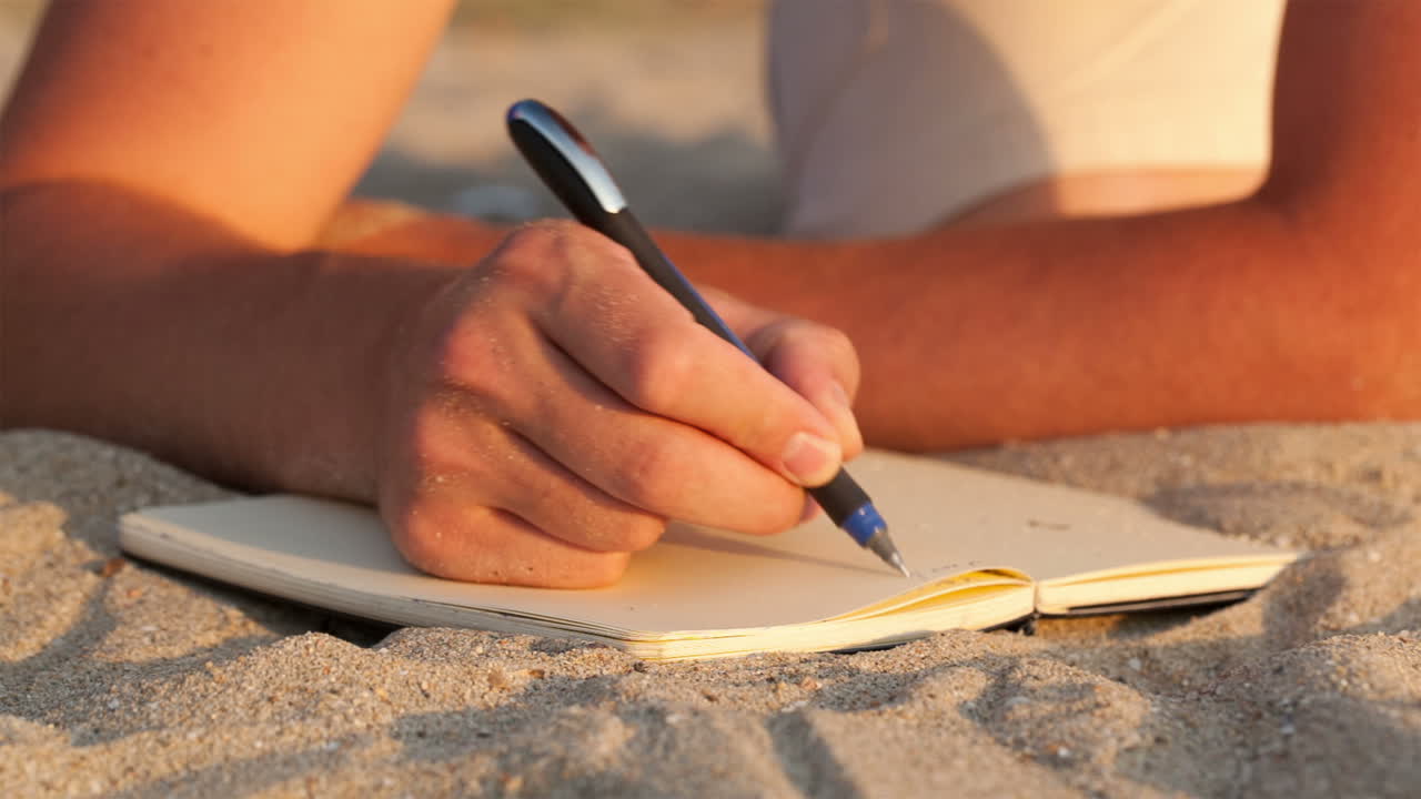 Man writing in his diary at the beach