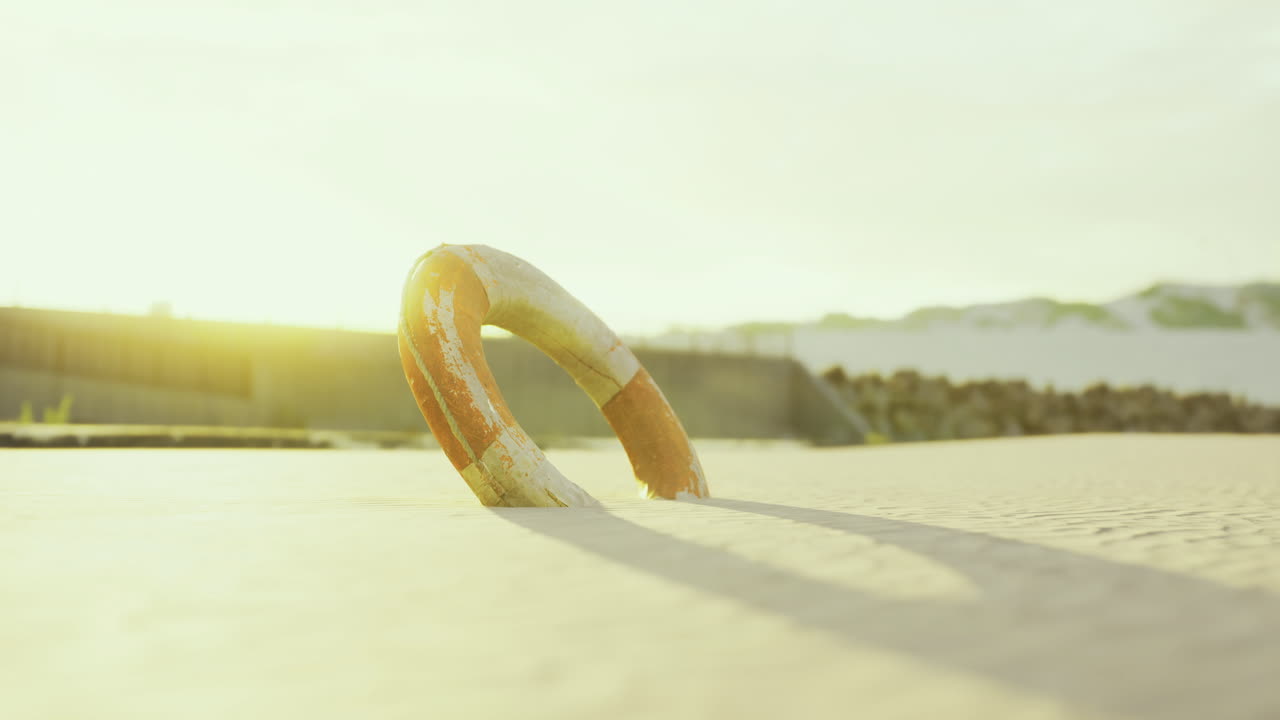 Lifebuoy resting peacefully on sandy shore at golden hour by the sea