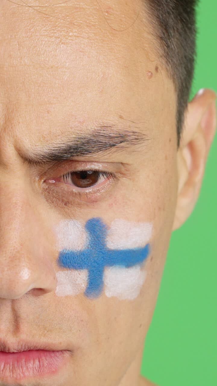 Serious man with a finnish flag painted on the face