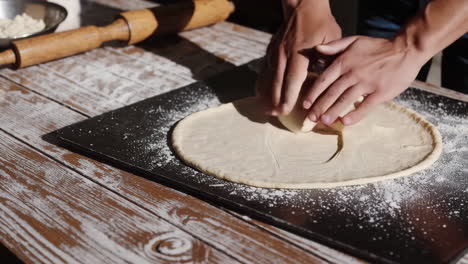 close-up of hands kneading dough on a floured surface