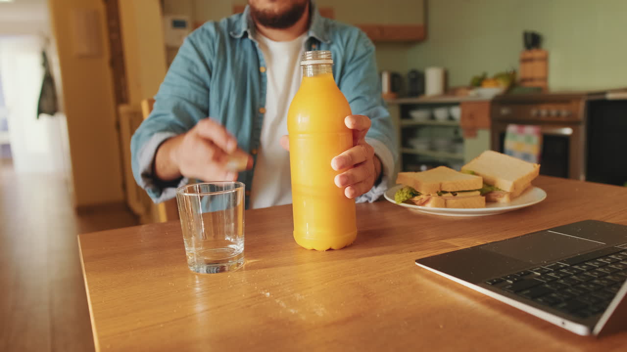Hombre vertiendo jugo de naranja en un vaso