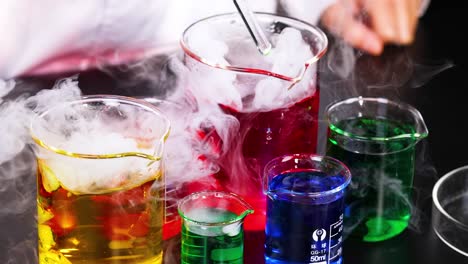 vibrant liquids reacting with smoke in beakers