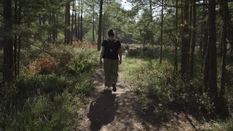 white-woman-in-her-thirties-walks-along-a-forest-path-in-Stilo,-Poland