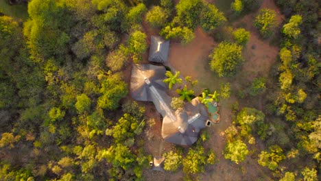 Aerial-top-down-view-of-rural-African-private-lodge-in-safari-park-at-sunset