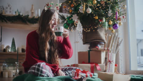 happy woman smelling aromatic fresh coffee during christmas at home