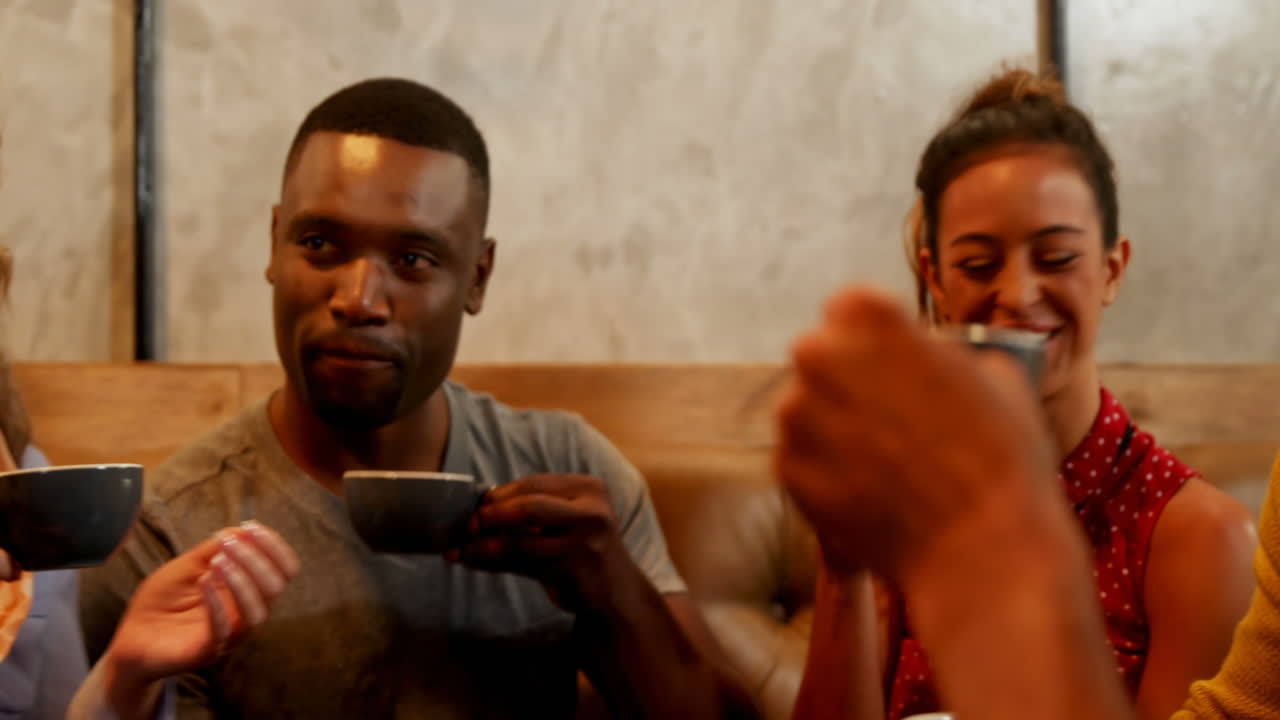 Gruppo di amici felici mentre prendono un caffè al ristorante 4K