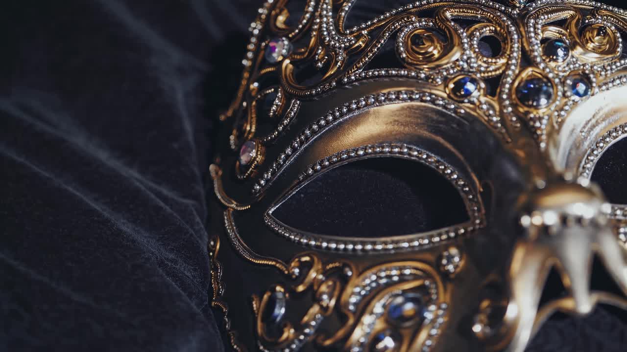 Video ravvicinato di una maschera da ballo in maschera decorata con intricati dettagli in oro e gioielli, ripresa dal basso