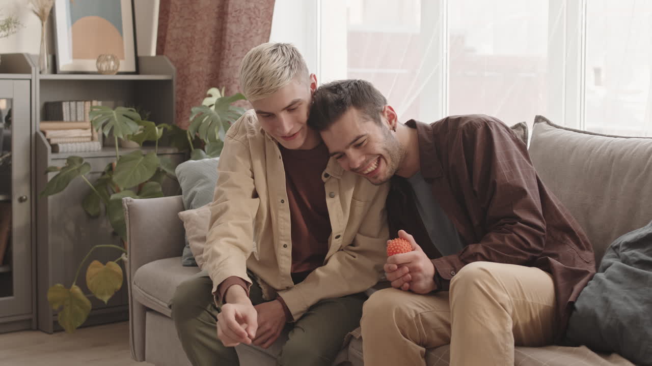 Two Young Men Training Dog at Home