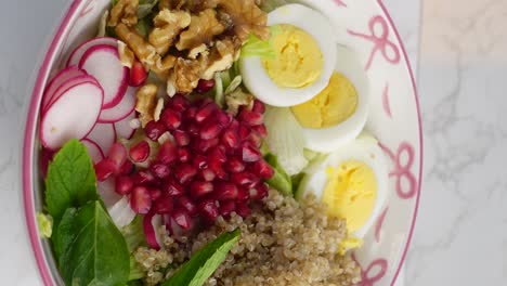 healthy quinoa salad with walnuts, pomegranate, and eggs