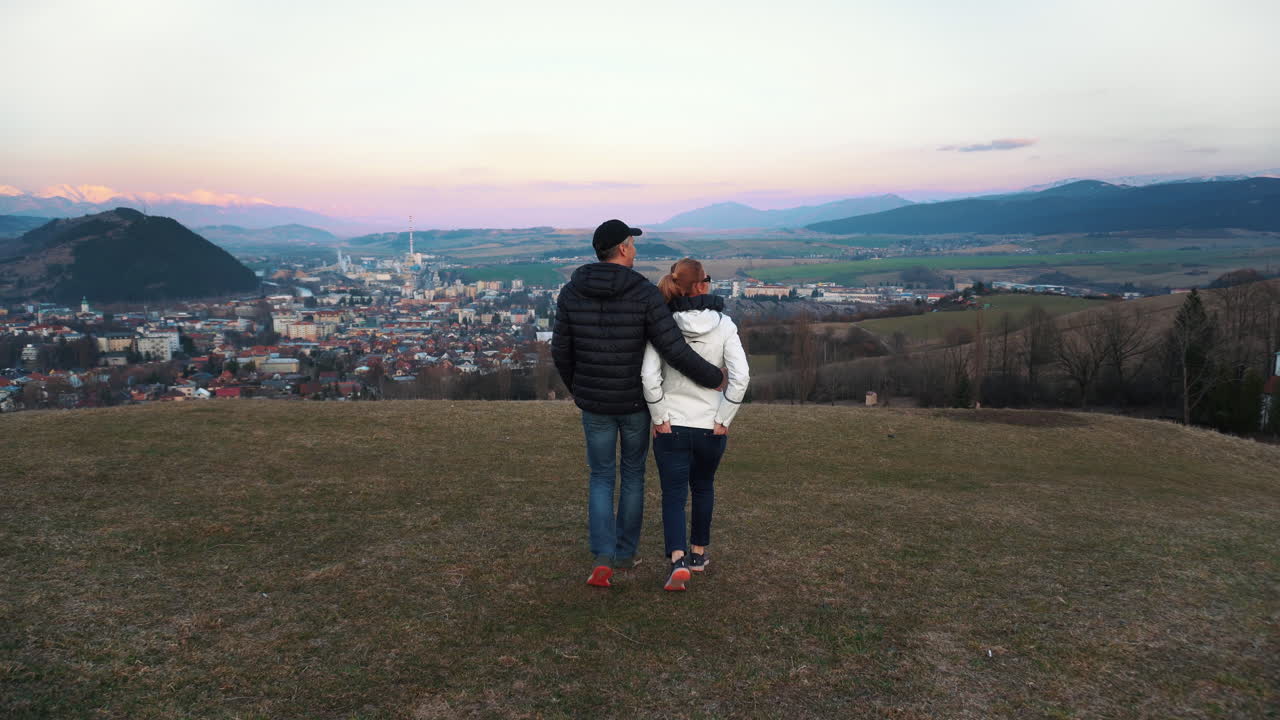 Couple Walking Down The Hill During Sunset In Ruzomberok In The Touristic Region Of Liptov, Slovakia - wide shot