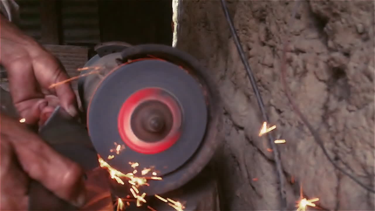 전기 그라인더로 낫의 칼날 갈기