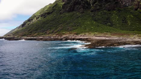 waves rolling up on a rock flat off the west coast of hawaii.