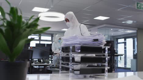 health worker wearing protective clothes cleaning the office using disinfectant