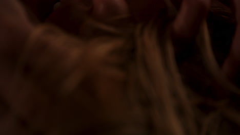 beautiful macro of a woman lying down and playing with her hair and looking at the camera in slow motion