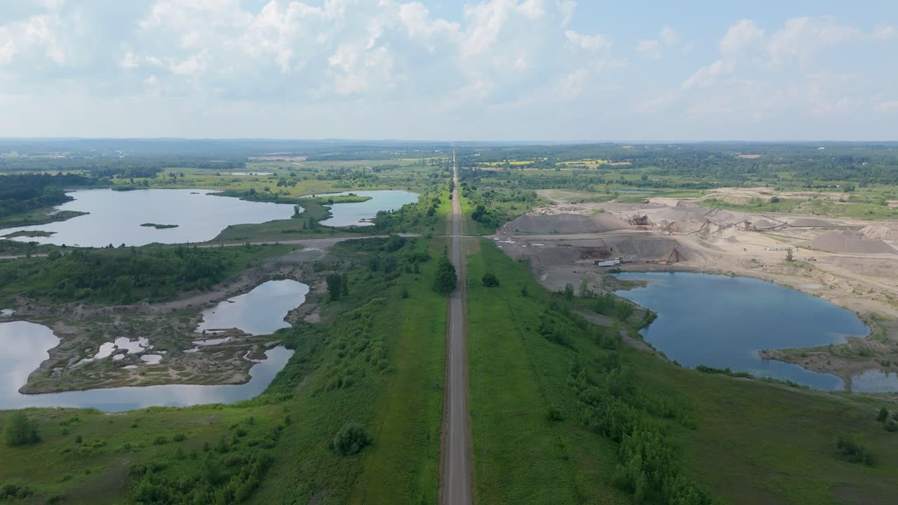 Aerial of quarry site with water and surrounding sand piles in Caledon