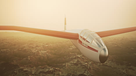 An-aerial-view-of-the-white-sailplane-with-no-propeller-calmly-gliding-in-the-sky,-over-snow-covered-mountains.-Flying-aerodynamic-aircraft-is-a-great-way-of-spend-leisure-time.