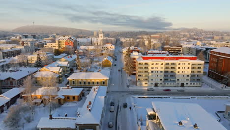 drone flying over snowy streets in kuopio city, sunny, winter morning in finland