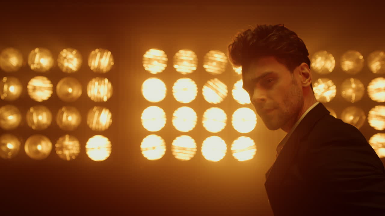 retrato de un hombre seductor mirando a la cámara con confianza en un club nocturno.