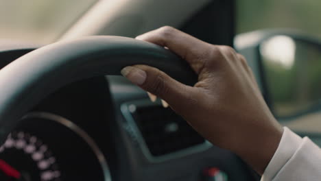 woman driving car with hands on steering wheel to control vehicle in city travelling on the road at rush hour to destination